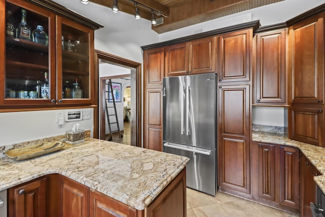 215 Whitehead St, Key West, FL 33040 - kitchen with high quality fridge, rail lighting, light stone counters, glass insert cabinets, and light tile patterned floors