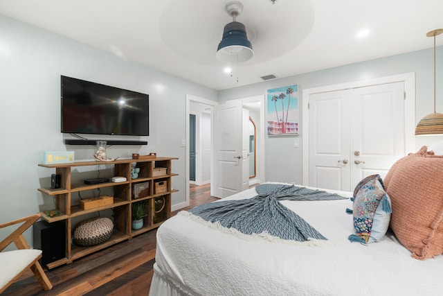 bedroom featuring ceiling fan, visible vents, baseboards, a closet, and dark wood finished floors