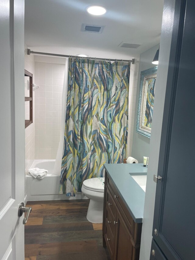 bathroom with visible vents, shower / tub combo with curtain, vanity, and wood finished floors