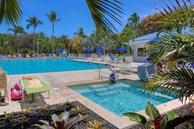 community pool with a patio area and area for grilling