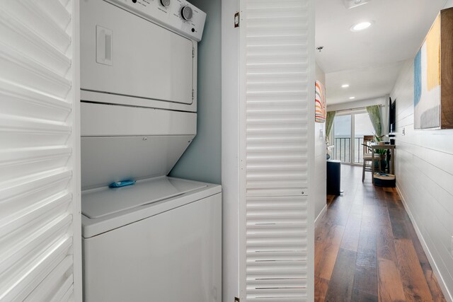 laundry room with stacked washing maching and dryer, wood-type flooring, laundry area, and recessed lighting