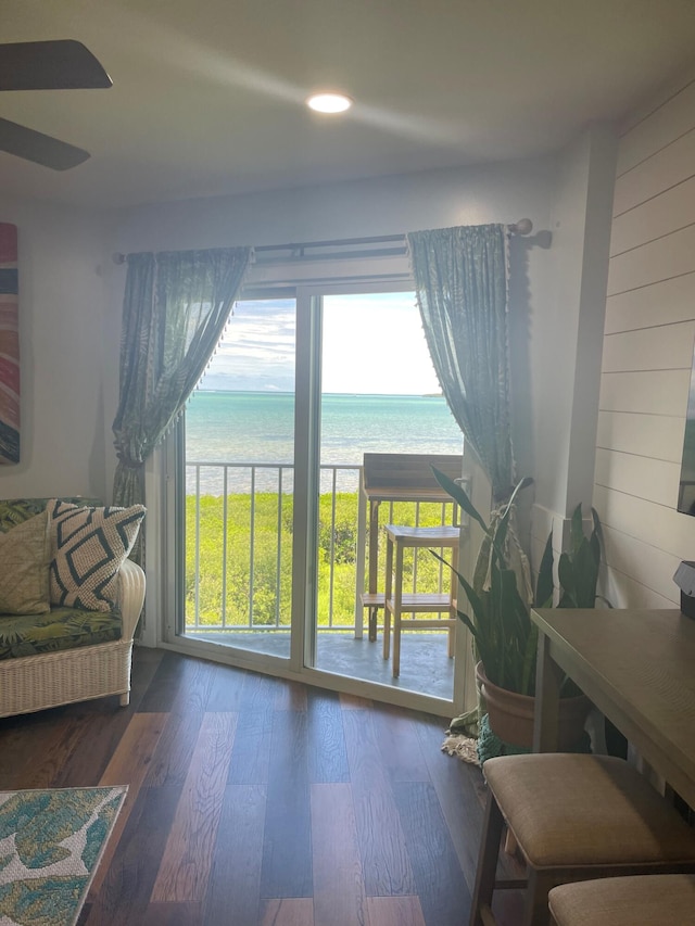 interior space with wood walls, a water view, and wood finished floors