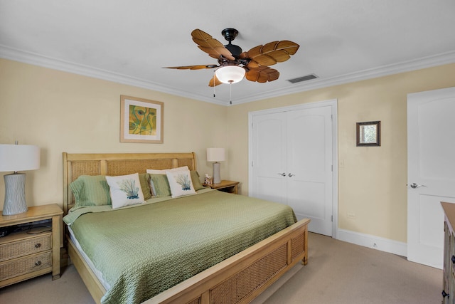 carpeted bedroom featuring ornamental molding, a closet, and ceiling fan