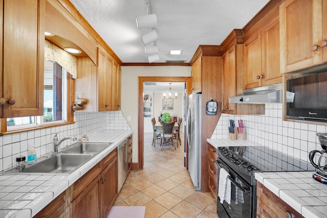 kitchen featuring light tile patterned flooring, tile countertops, tasteful backsplash, sink, and stainless steel appliances