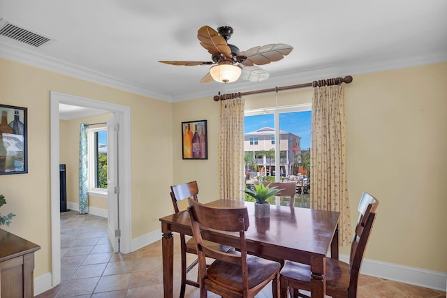 tiled dining area featuring ceiling fan, ornamental molding, and a wealth of natural light