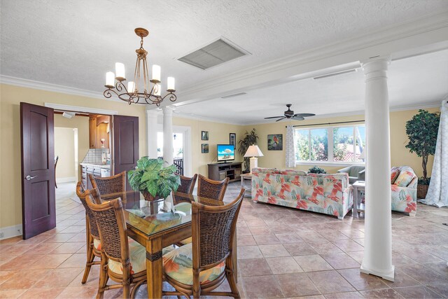 tiled dining room with ornate columns, ornamental molding, ceiling fan with notable chandelier, and a textured ceiling