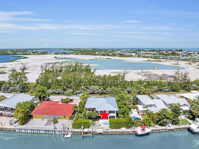 birds eye view of property with a water view and a beach view