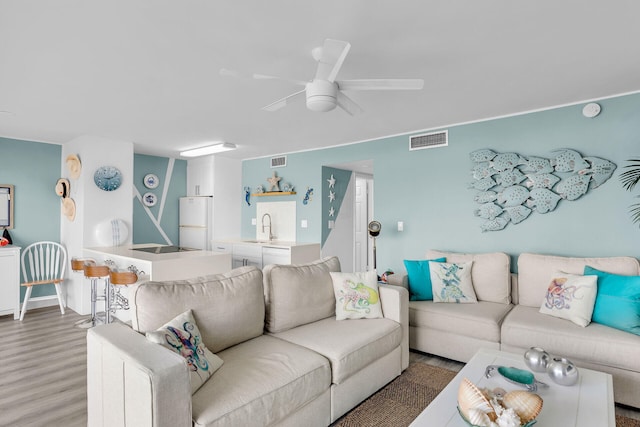 living room with sink, hardwood / wood-style floors, and ceiling fan