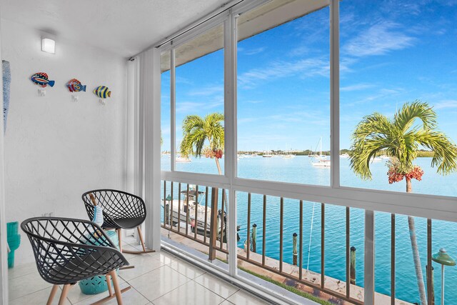 sunroom featuring a water view