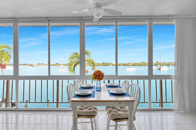 sunroom / solarium with a water view and ceiling fan