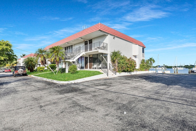 view of front facade featuring a balcony and a front yard