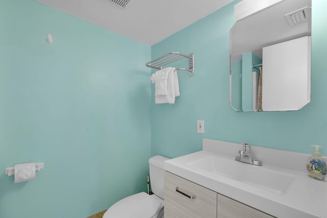 bathroom featuring visible vents, toilet, and vanity