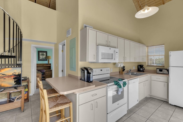 kitchen featuring high vaulted ceiling, light tile patterned flooring, white appliances, white cabinetry, and a sink