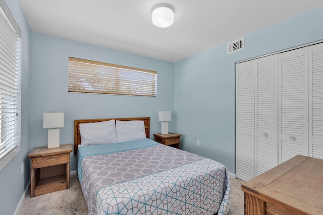 carpeted bedroom featuring visible vents, baseboards, and a closet