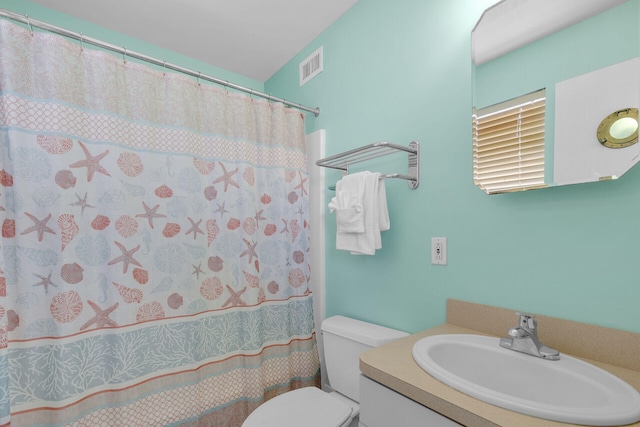 full bathroom featuring vanity, curtained shower, toilet, and visible vents