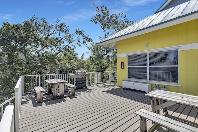 wooden terrace with area for grilling and outdoor dining area