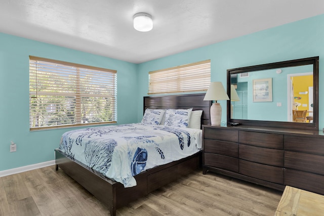 bedroom featuring baseboards and wood finished floors