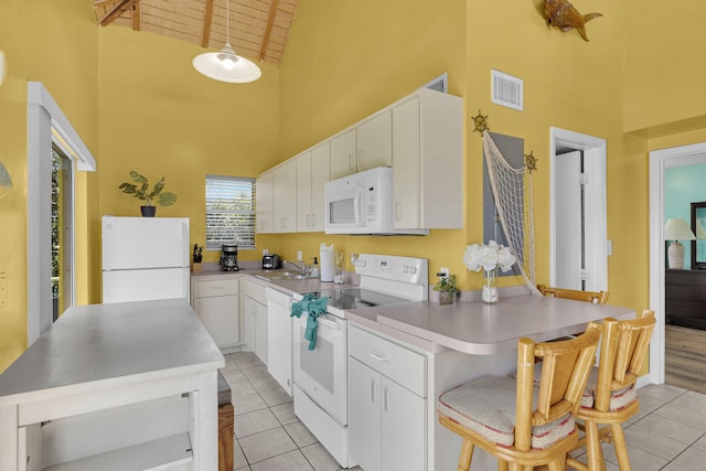 kitchen featuring visible vents, high vaulted ceiling, a sink, white appliances, and white cabinets