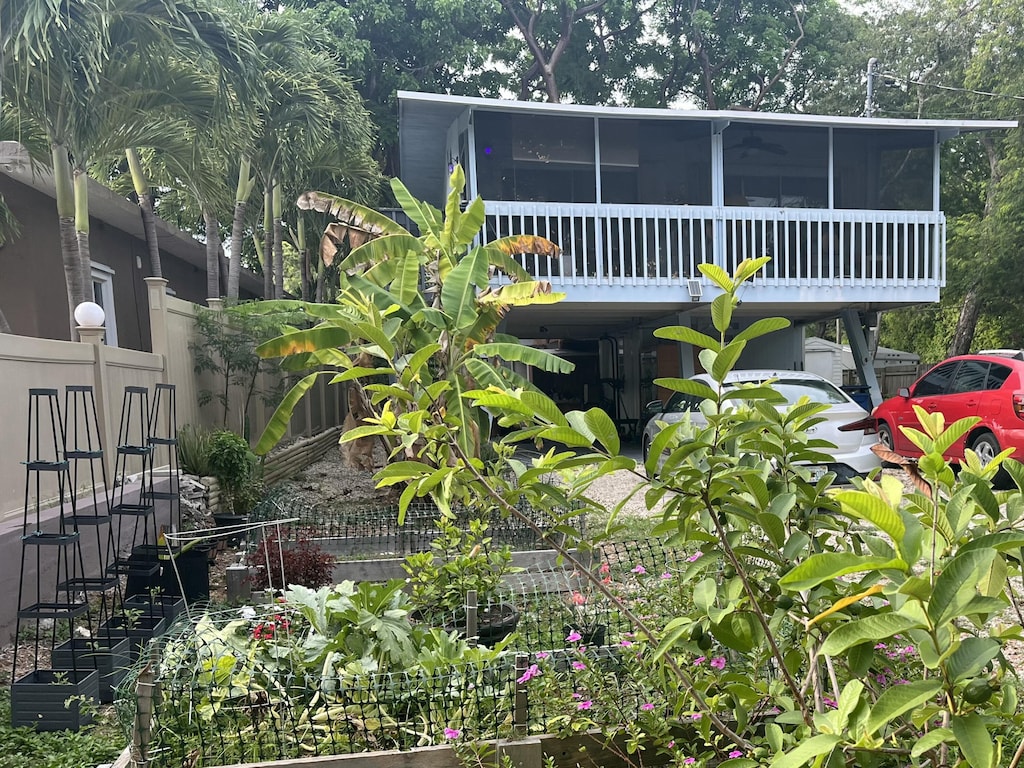 141 Gumbo Limbo Dr, Key Largo, FL 33037 - view of front facade featuring a sunroom and a carport
