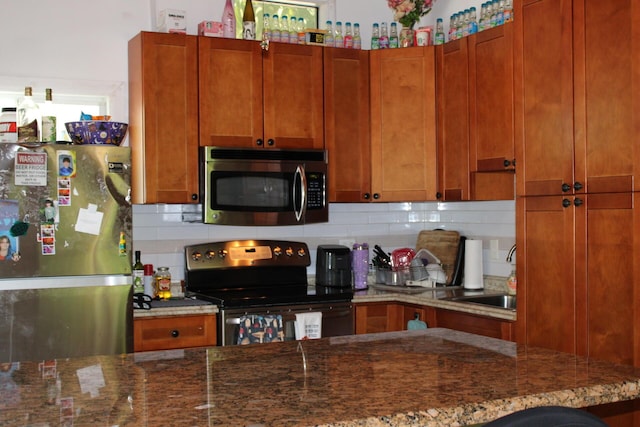 141 Gumbo Limbo Dr, Key Largo, FL 33037 - kitchen with stainless steel appliances, decorative backsplash, dark stone counters, and brown cabinetry