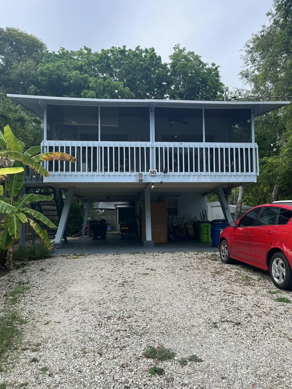 141 Gumbo Limbo Dr, Key Largo, FL 33037 - view of front facade featuring a sunroom, driveway, a carport, and stairway