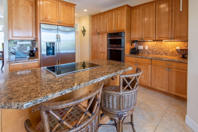 kitchen with light tile patterned floors, stainless steel appliances, a kitchen breakfast bar, a center island, and decorative backsplash