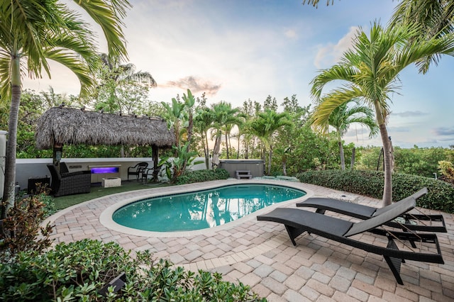 view of swimming pool featuring a hot tub, a gazebo, an outdoor living space, and a patio area