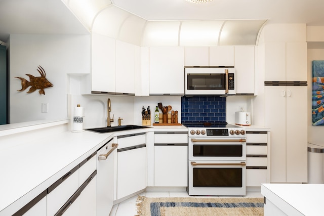 kitchen featuring tasteful backsplash, sink, white cabinets, and white appliances