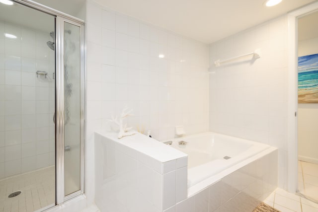 bathroom featuring separate shower and tub, tile patterned flooring, and tile walls