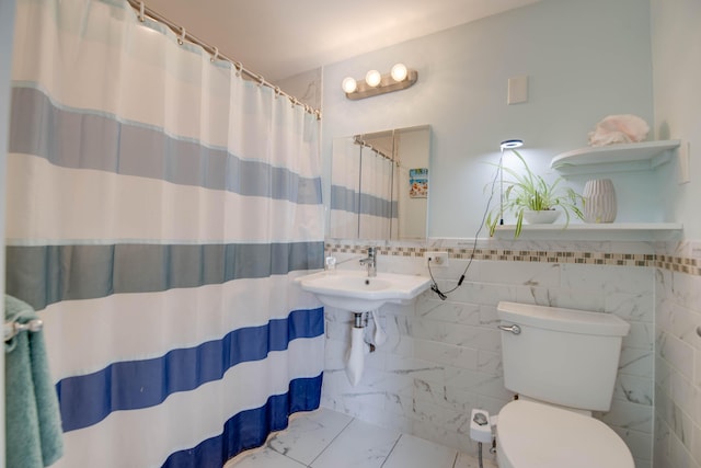 bathroom featuring tile walls, sink, a shower with curtain, and toilet