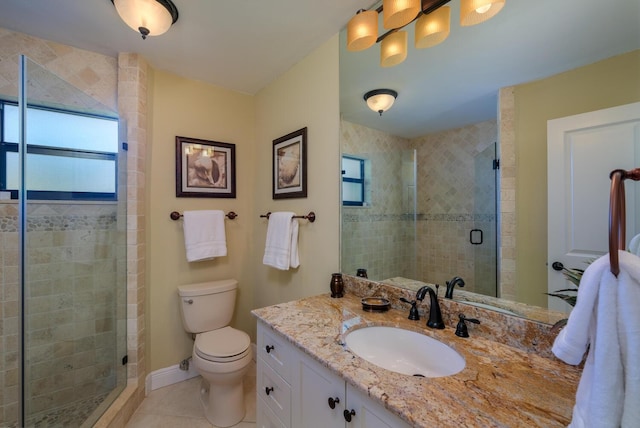 bathroom featuring vanity, a shower with door, tile patterned floors, and toilet