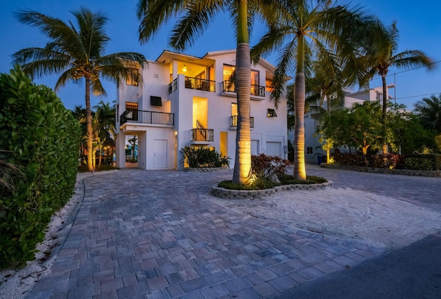 mediterranean / spanish-style house featuring a garage and a balcony