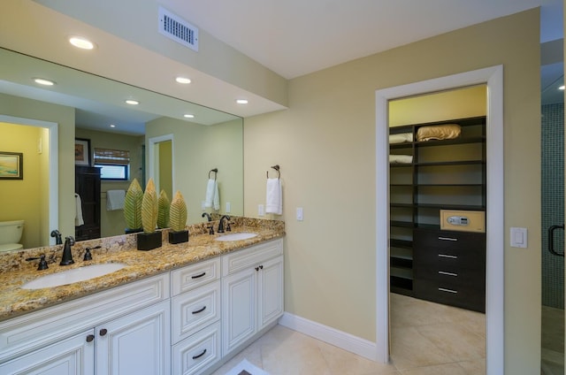 bathroom with vanity, toilet, a shower with shower door, and tile patterned flooring