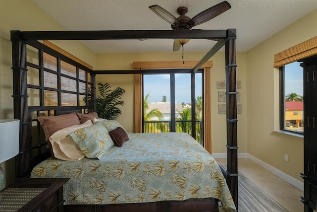 bedroom featuring tile patterned flooring, a textured ceiling, and access to outside