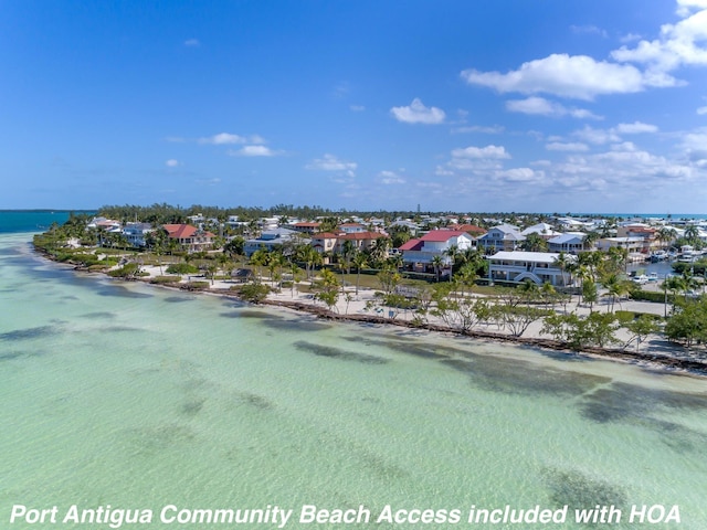 birds eye view of property with a water view and a view of the beach