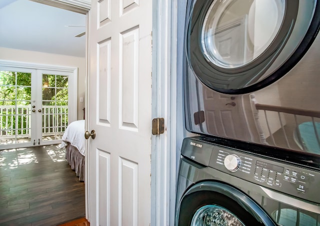 clothes washing area with dark hardwood / wood-style floors, stacked washing maching and dryer, and french doors