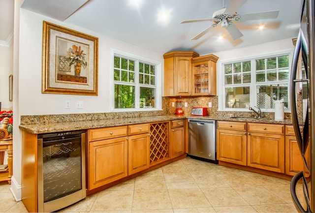 kitchen with black refrigerator, beverage cooler, decorative backsplash, stainless steel dishwasher, and light stone countertops