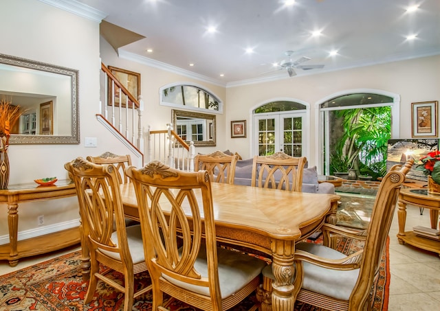 tiled dining space with ornamental molding, french doors, and ceiling fan