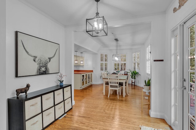 dining area with crown molding and light wood-type flooring