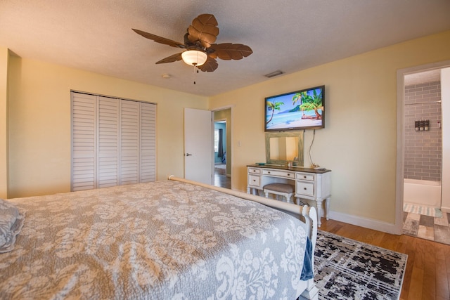 bedroom featuring hardwood / wood-style flooring, ceiling fan, a closet, and a textured ceiling