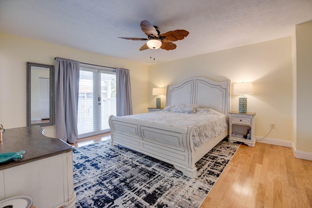 bedroom featuring ceiling fan, access to outside, a textured ceiling, and light hardwood / wood-style floors