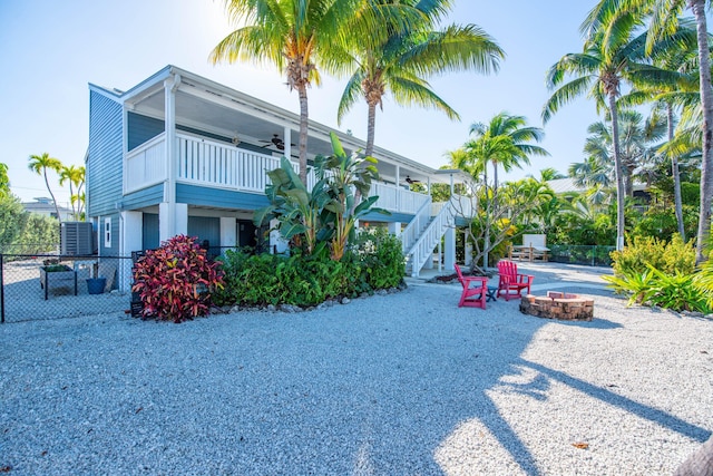 view of side of property with ceiling fan and a fire pit