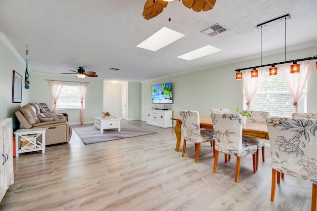 dining room with ornamental molding, ceiling fan, a textured ceiling, and light wood-type flooring