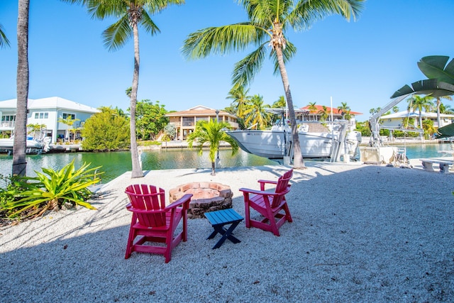 exterior space with a fire pit, a boat dock, and a water view