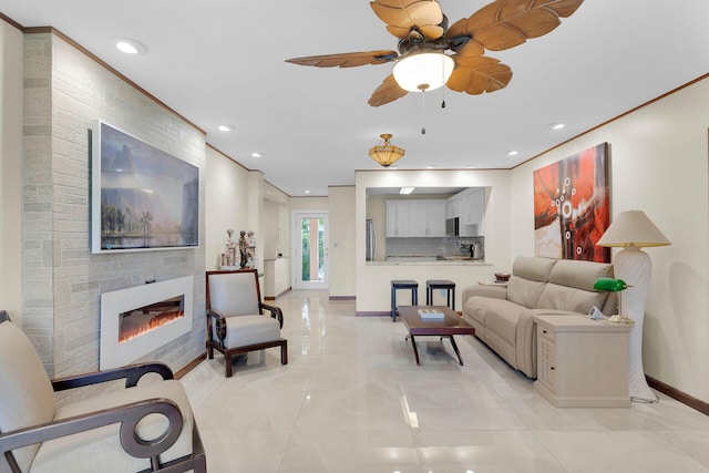 tiled living room with ceiling fan, ornamental molding, and a fireplace