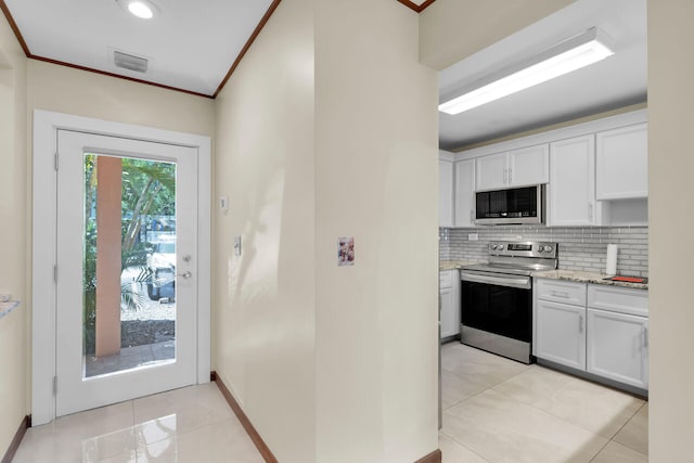 kitchen with stainless steel appliances, white cabinetry, ornamental molding, and backsplash