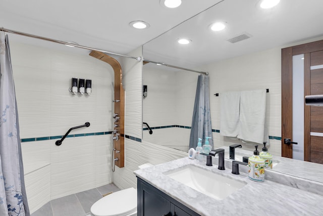 bathroom with vanity, toilet, tile walls, and a shower with shower curtain