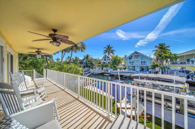 balcony with a water view and ceiling fan