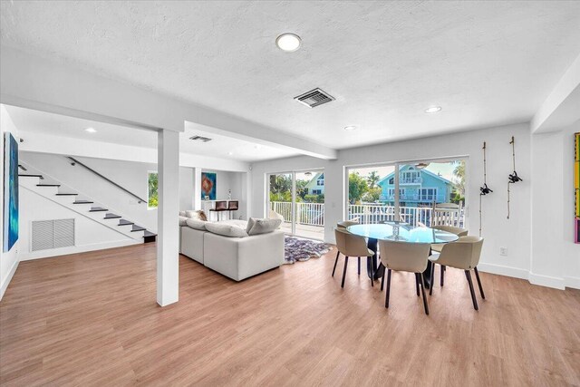 dining room featuring light hardwood / wood-style floors and a textured ceiling