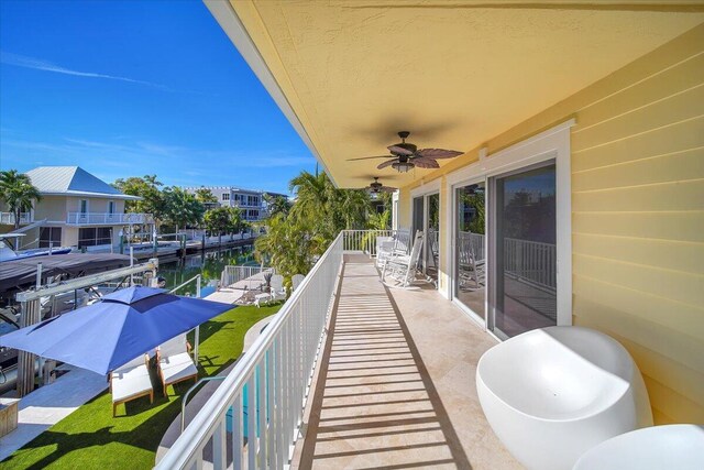 balcony featuring ceiling fan and a water view